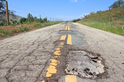 Road with multiple potholes.